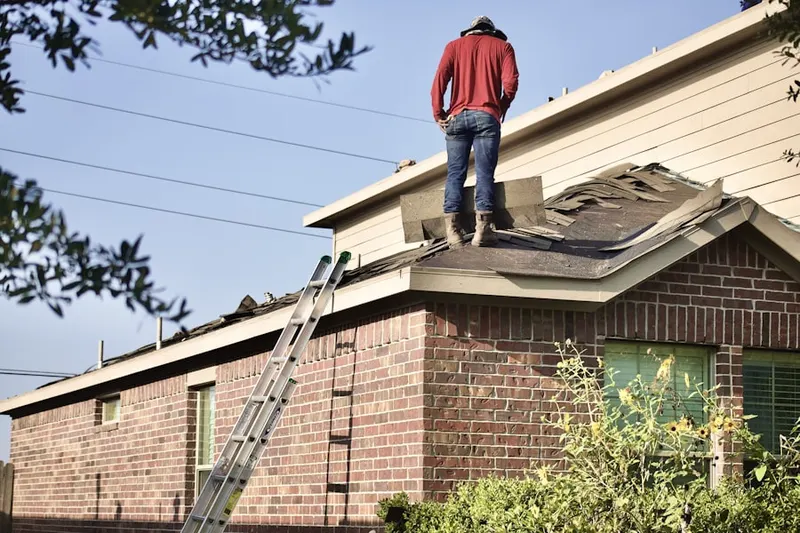Professional roofer working on a residential roof in Victor Haven